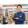 笑顔でセブンイレブンのスムージーと専用マシンを紹介する日本人男性のコンビニ店長、齋藤正志。