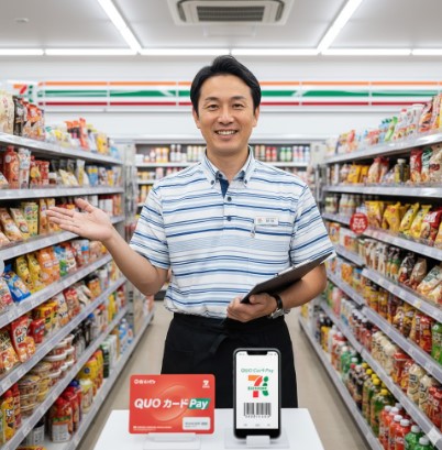 コンビニ店長が店内でQUOカードとQUOカードペイについて説明している様子