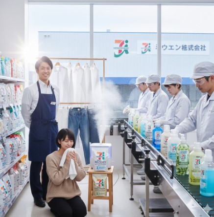 セブンイレブンの洗剤が陳列された棚。背景には工場のような施設がぼんやりと見え、製品の信頼性を象徴している。