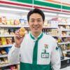 コンビニ店長が店内で「ぴーなっつ最中」を持って笑顔で立つ様子。