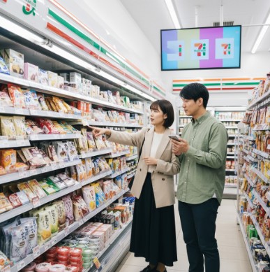 セブンイレブンの店内で和菓子を探す日本人カップルの様子。