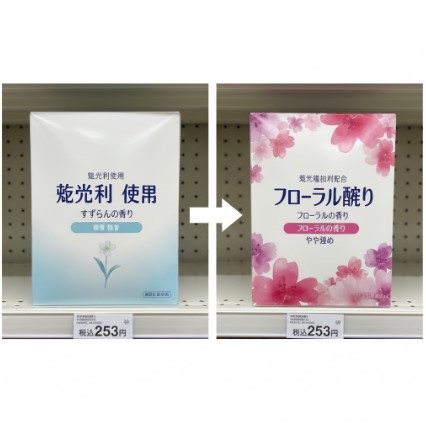 棚に置かれたセブンイレブンの粉末洗濯洗剤の旧パッケージ(すずらんの香り、蛍光剤不使用)と新パッケージ(フローラルの香り、蛍光増白剤配合)が左右に並べられ、中央に白い矢印でリニューアル前後の変化を示している。