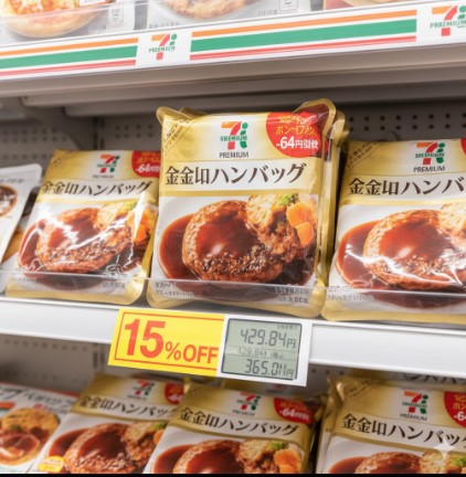 セブンイレブンの陳列棚に並んだ「金 の ハンバーグ」のパッケージ。15%OFFで割引された価格がデジタル表示された値札とともに写っている。
