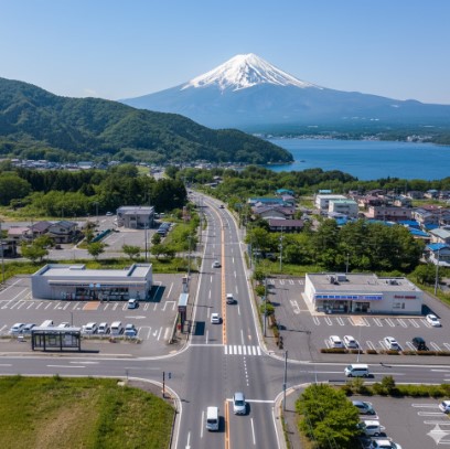 山間部を通る日本の国道沿いに、2軒の異なるコンビニが近接して建っている様子。